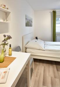 a white bedroom with a bed and a table at Apartments 4 YOU - Lange Straße in Fürth