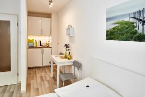 Zimmer mit einem Schreibtisch und einer Küche mit einem Tisch in der Unterkunft Apartments 4 YOU - Lange Straße in Fürth