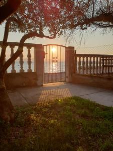 a fence with the sun shining on the ocean at Apartments Igor in Bibinje