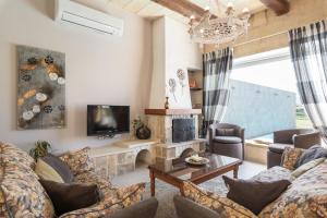 a living room with a couch and a tv at Twilight Holiday Home in Għasri