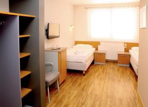 Cette chambre comprend deux lits, un bureau et une fenêtre. dans l'établissement Sedlecký Dvůr, à Sedlec