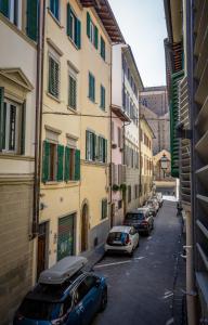 um grupo de carros estacionados numa rua com edifícios em Acacia Firenze - Melograno em Florença