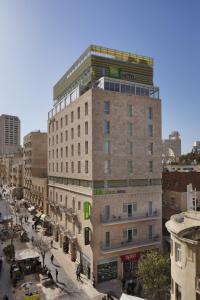 um edifício alto com uma placa no topo em Ibis Styles Jerusalem City Center - An AccorHotels Brand em Jerusalém