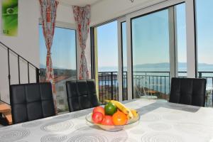 a bowl of fruit on a table in a room with windows at Tri sriće in Senj