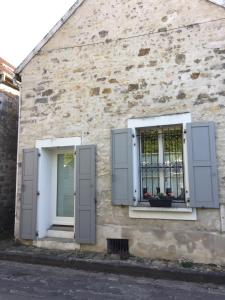 two windows with shutters on a stone building at A l'orée de la forêt in Recloses