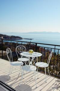 a table and chairs on a balcony with the ocean at Tri sriće in Senj