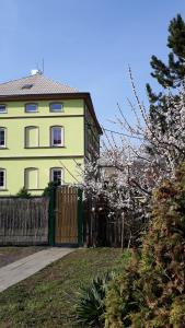 een geel huis met een hek ervoor bij Olsinky in Ústí nad Labem