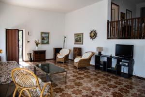 a living room with a tv and chairs and a table at La Timpa in Acireale