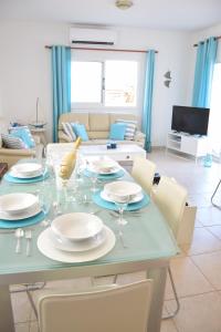 a dining room with a table with plates and wine glasses at Sol y Mar Malama Villa in Paralimni