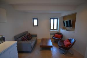 a living room with a couch and a table and chairs at Ramatuelle Maison de Village in Ramatuelle
