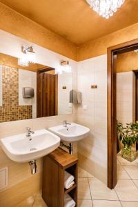 Baño con 2 lavabos y espejo en David Boutique Hotel, en Cracovia