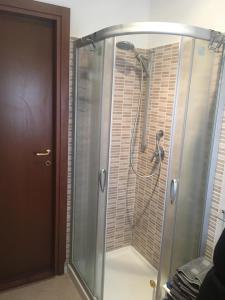 La salle de bains est pourvue d'une douche avec une porte en verre. dans l'établissement apartmentsIT via Verona 16, à Alba Adriatica