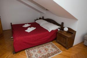 a bedroom with a bed with a red blanket at Villa Kukuljica in Zaton