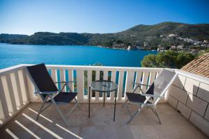 a balcony with two chairs and a table and the water at Villa Kukuljica in Zaton