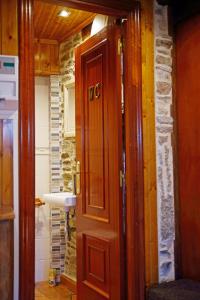 una puerta de madera en una habitación con una pared de piedra en Aqua Rooms Sarria, en Sarria