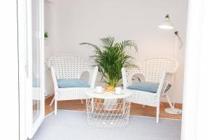 a porch with wicker chairs and a table with a plant at KASANZAS in Fuentespina