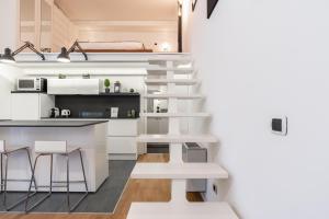 a small kitchen with white cabinets and a staircase in a room at Urban District Apartments - Milan Isola Lancetti Loft 1BR in Milan