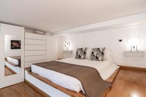a white bedroom with a large bed and two lamps at Urban District Apartments - Milan Isola Lancetti Loft 1BR in Milan