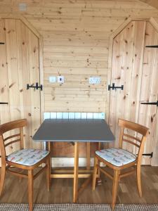 uma mesa e duas cadeiras numa sauna em Sutor Coops The Den with Hot Tub em Cromarty