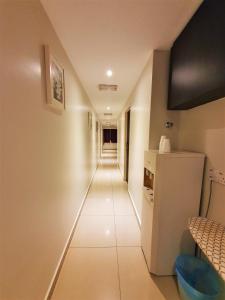a hallway with a white refrigerator in a room at De UPTOWN Hotel @ Damansara Uptown in Petaling Jaya