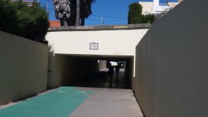 a tunnel leading into a building with a person walking through it at Beach House Cascais in Estoril