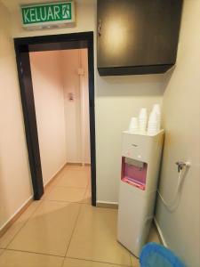a kitchen with a refrigerator with a sign on the wall at De UPTOWN Hotel @ Damansara Uptown in Petaling Jaya