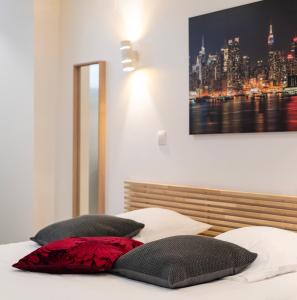 duas almofadas numa cama com um quadro na parede em CityCosy Strasbourg - Studio Hirtz Orangerie em Estrasburgo