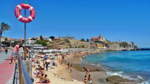 a group of people on a beach with a life preserver at Beach House Cascais in Estoril