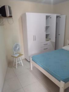 um quarto com uma cama, uma secretária e uma cadeira em Pousada Residencial Caroa em Florianópolis
