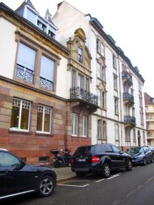 a building with cars parked in front of it at CityCosy Strasbourg - Studio Hirtz Orangerie in Strasbourg