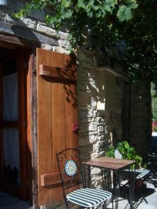 une table et des chaises installées à côté d'une porte en bois dans l'établissement Eleni's Cottage, à Apsiou