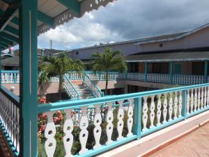 uma varanda com um corrimão azul e palmeiras em 22 plaza rosada em Las Terrenas