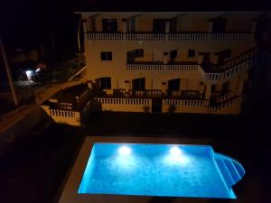 a swimming pool in front of a building at night at Apartamentos Nuevo Amanecer in Río San Juan