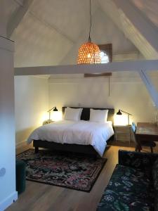 a bedroom with a large white bed and a table at NineT7 in Tilburg