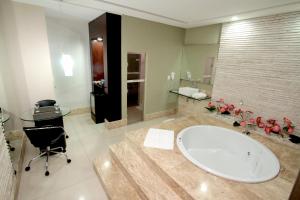 a bathroom with a tub and a desk and a sink at Raru's Motel Via Costeira (Adult Only) in Natal +24 photos