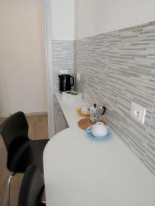 a kitchen with a white counter and a black chair at ARNO ROOMS VERONA in Verona