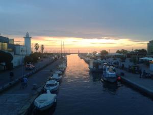 a group of boats docked in a canal at sunset at La Pineta Apartment in Viareggio