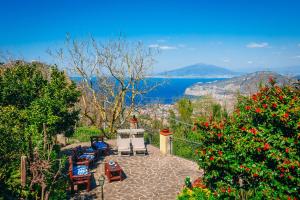 a patio with chairs and a view of the water at Villa Rossella Sorrento in Sorrento
