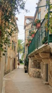 un callejón en un casco antiguo con balcón en Sophos, en Supetar