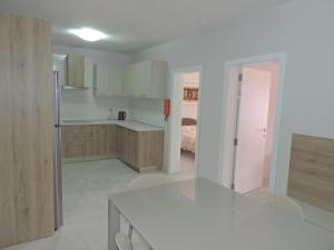 a kitchen with a table and a room with a bed at Antros, Apartment 1 in Xlendi