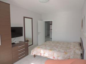 1 dormitorio con cama, tocador y espejo en Antros, Apartment 1, en Xlendi