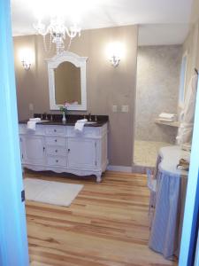 a bathroom with a white vanity and a mirror at The Wanderlust Hotel in Sturgeon Bay