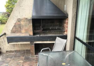 a grill on a patio with a table and a chair at Lofts - Club de campo San Pedro in San Pedro
