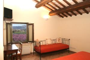 a bedroom with a red bed and a window at FATTORIA DELLA BILANCIA in San Giovanni in Marignano