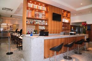 a bar with black stools in a restaurant at Flat Executive Beira Mar in Recife