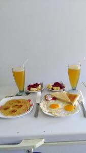 a table with two plates of food and two glasses of orange juice at Gula Juruh Beach Front in Amed +76 photos