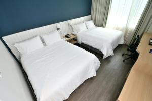 Habitación de hotel con 2 camas con sábanas blancas en Holiday Inn Express Asuncion Aviadores , an IHG Hotel en Asunción