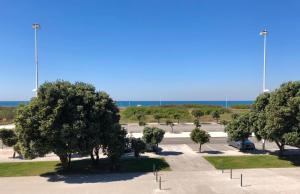 een parkeerplaats met bomen en de oceaan op de achtergrond bij VMO Apartment in Vila do Conde