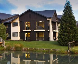 a house with a pond in front of it at Village Lake Apartments in Hanmer Springs