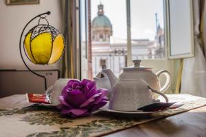 a tea pot and a flower on a table at Cavour Il Conte Camillo in Palermo